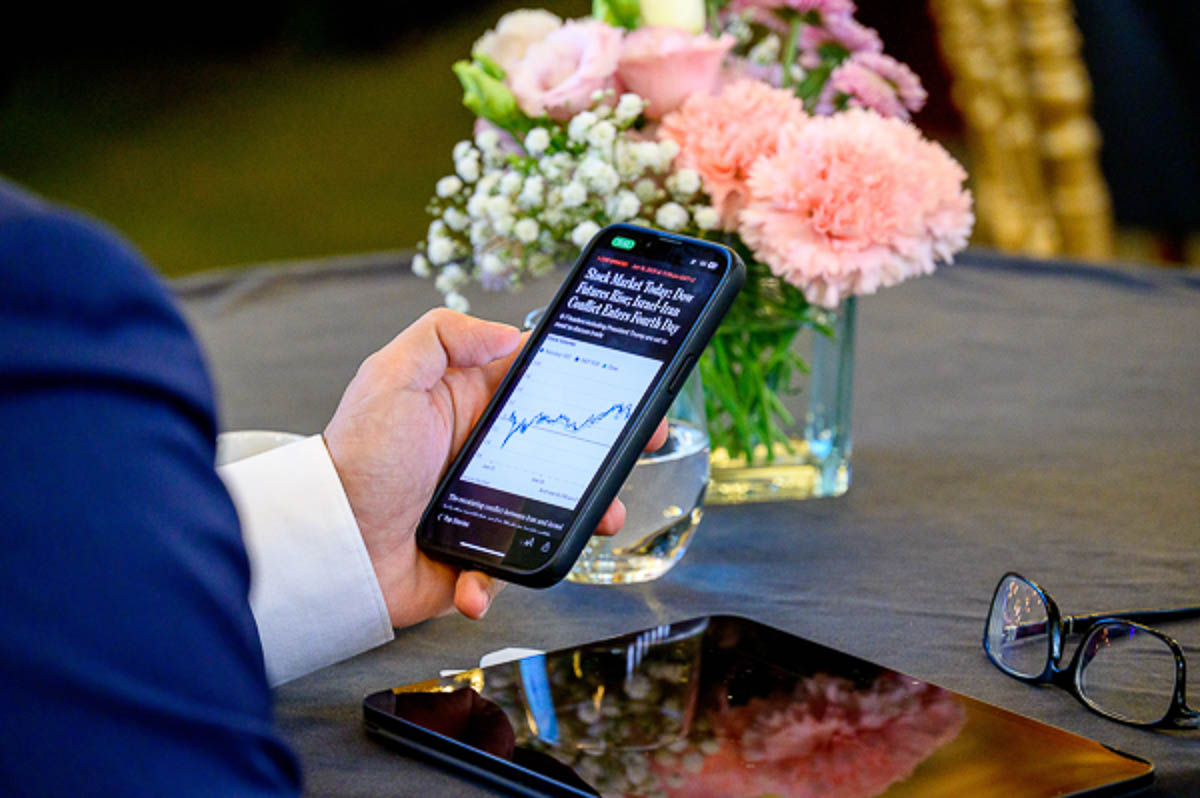 Business attendee checking financial data on smartphone